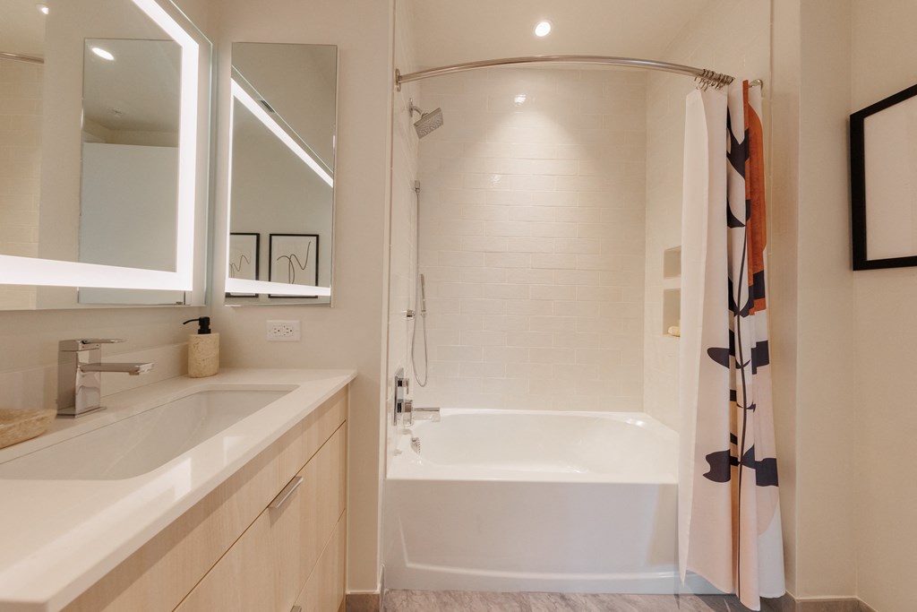 a bathroom with a tub and a sink and a shower