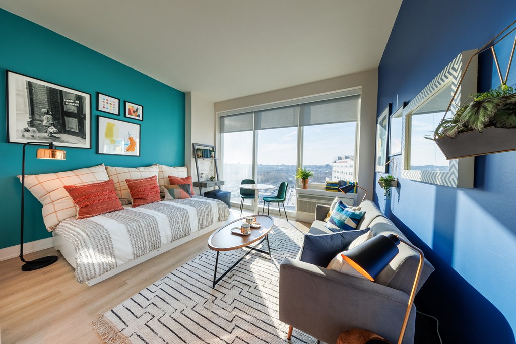 a living room with a bed and a blue accent wall