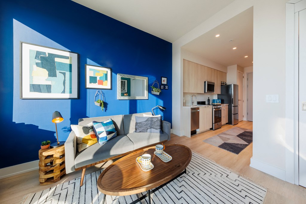 a living room with a blue wall and a couch and a table