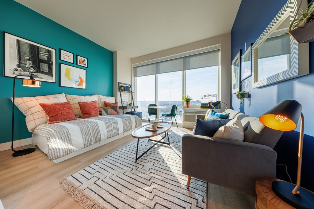 a living room with a bed and a blue accent wall
