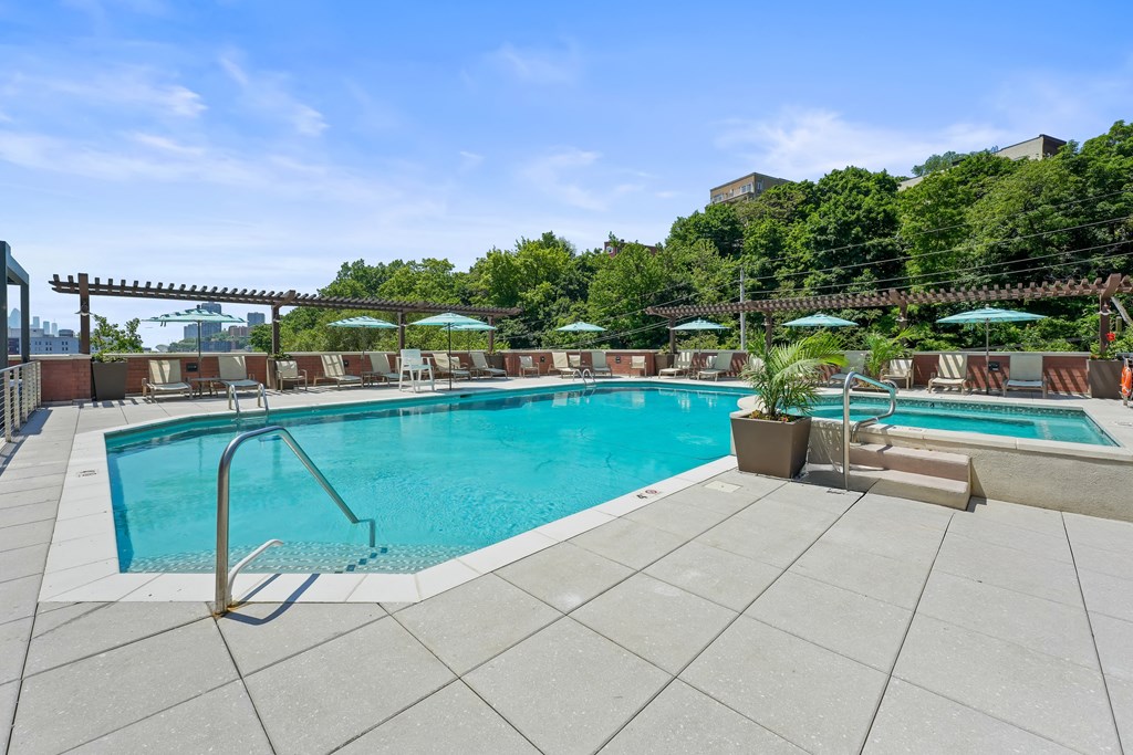 a swimming pool with chairs and umbrellas on a patio next to a pool