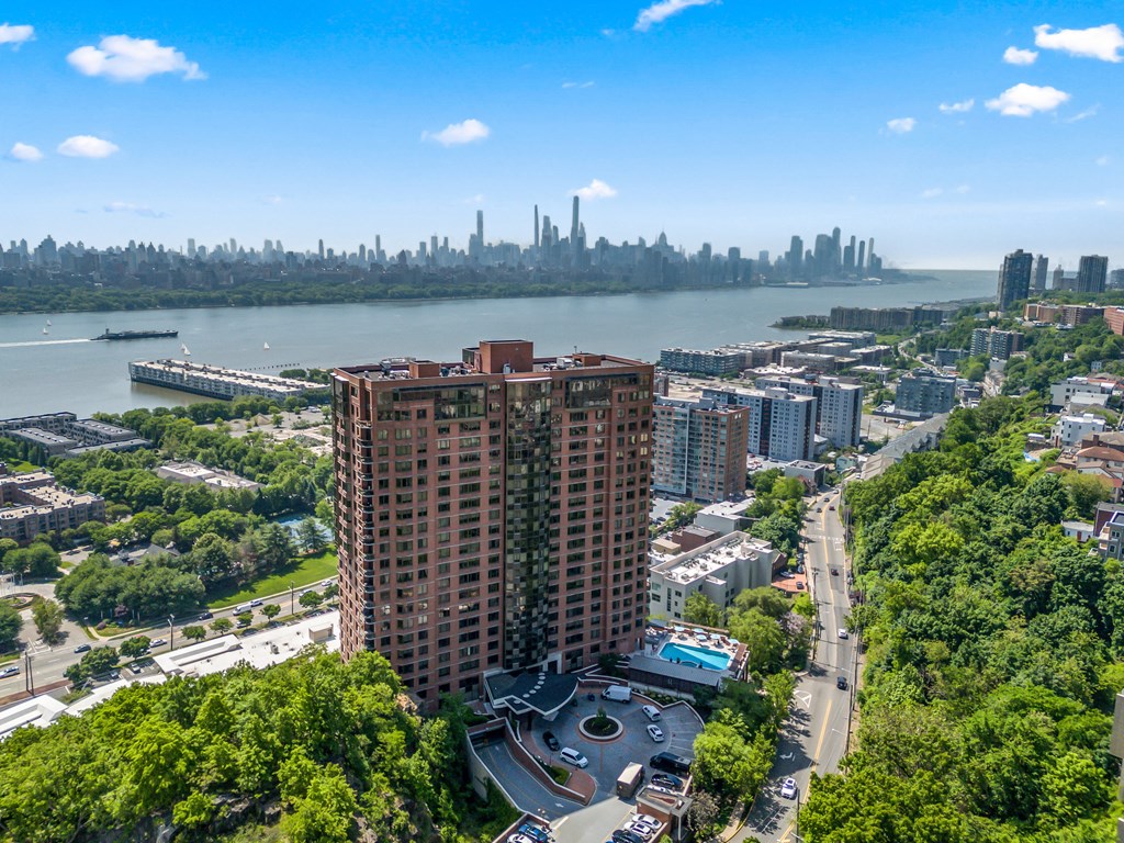 an aerial view of an apartment building with the city in the background