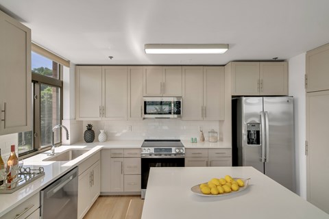 A kitchen with a bowl of lemons on the counter.