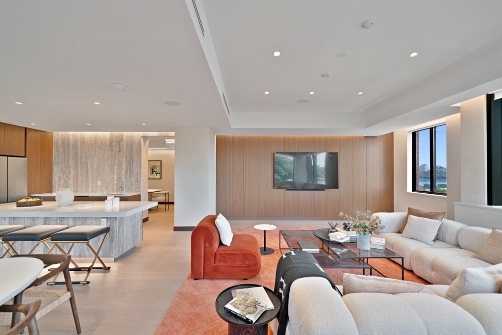 a living room with couches and chairs and a kitchen with a television