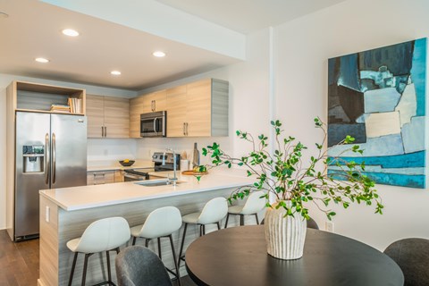 A modern kitchen with a dining table and chairs.