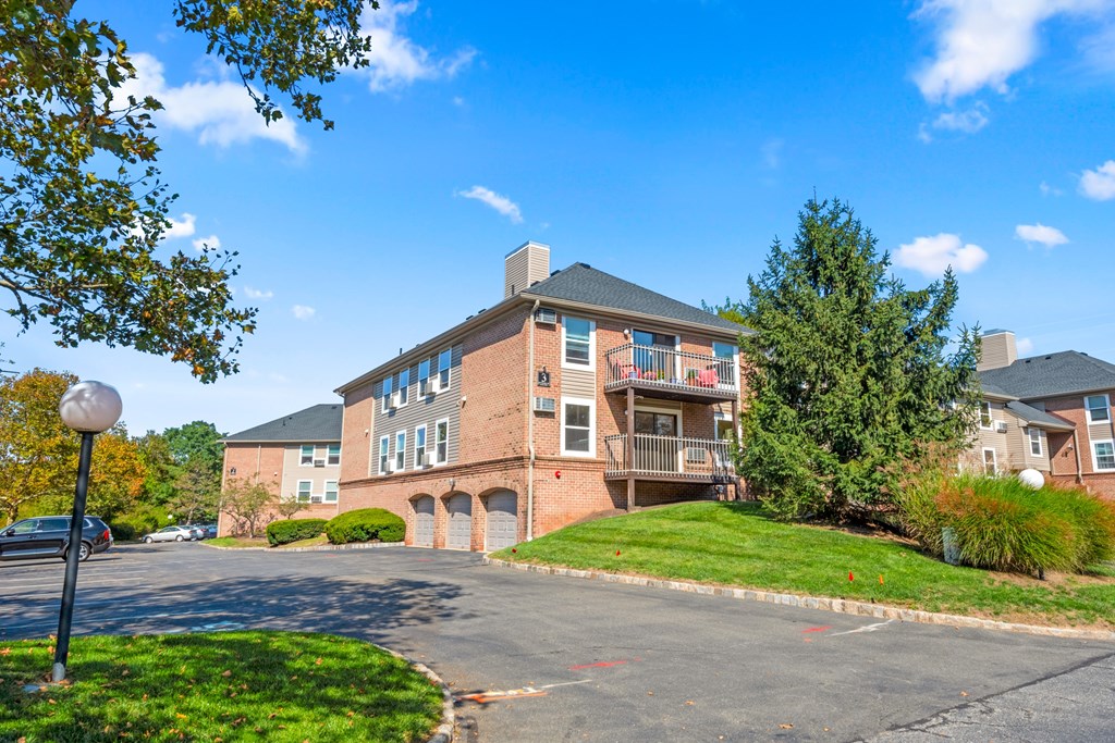 A large apartment complex with a parking lot in front.