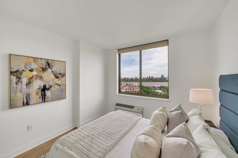 A bedroom with a large bed and a painting on the wall.