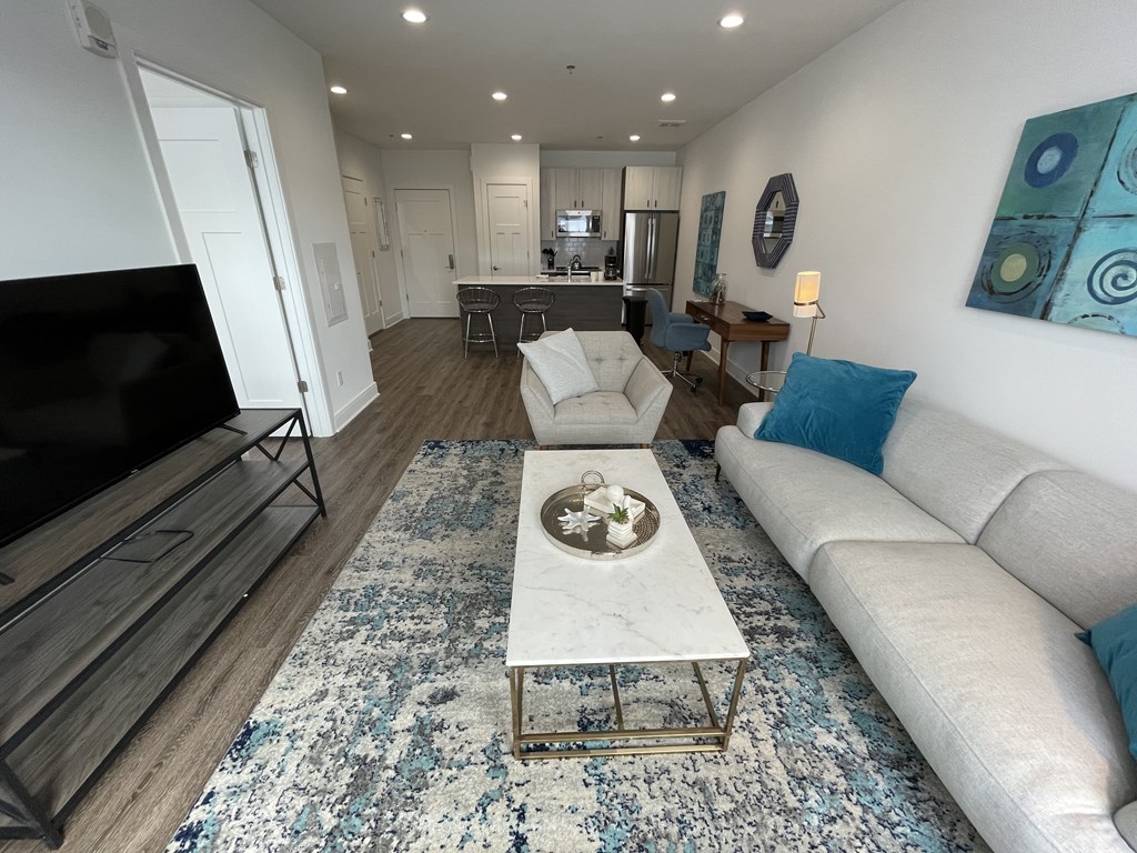 A modern living room with a white sofa and a coffee table.