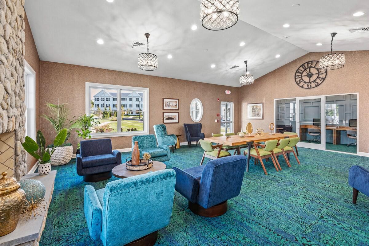 A living room with blue chairs and a green rug.