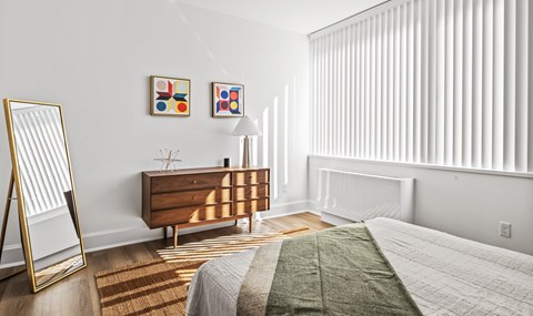 A bedroom with a bed, dresser, and mirror.