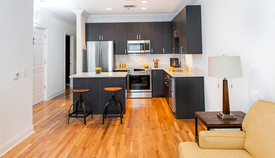 A modern kitchen with dark wood cabinets and a white fridge.