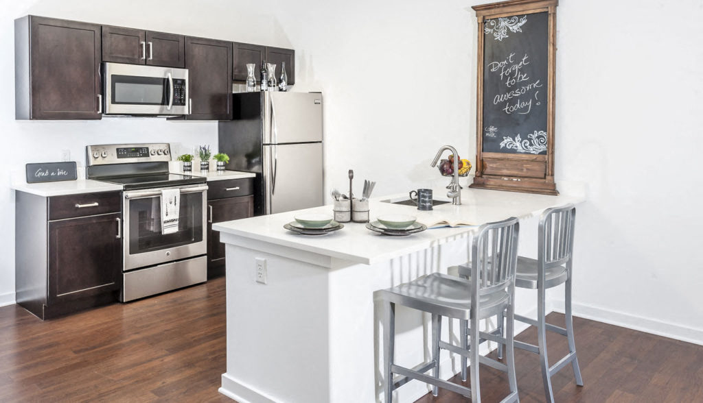 A kitchen with a white fridge and a chalkboard on the wall.