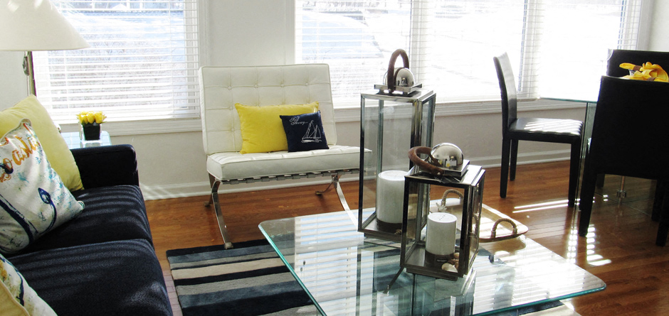 A living room with a white chair and a glass table.