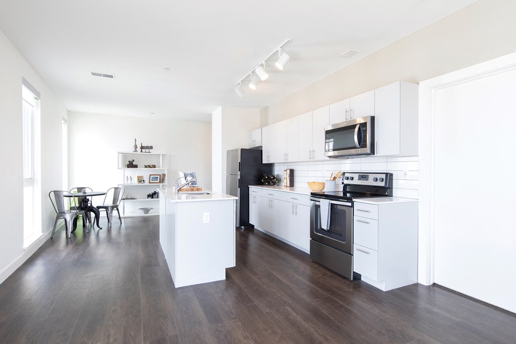 A modern kitchen with white cabinets and appliances.
