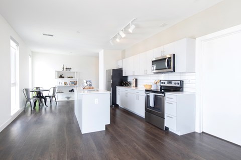 A modern kitchen with white cabinets and stainless steel appliances.