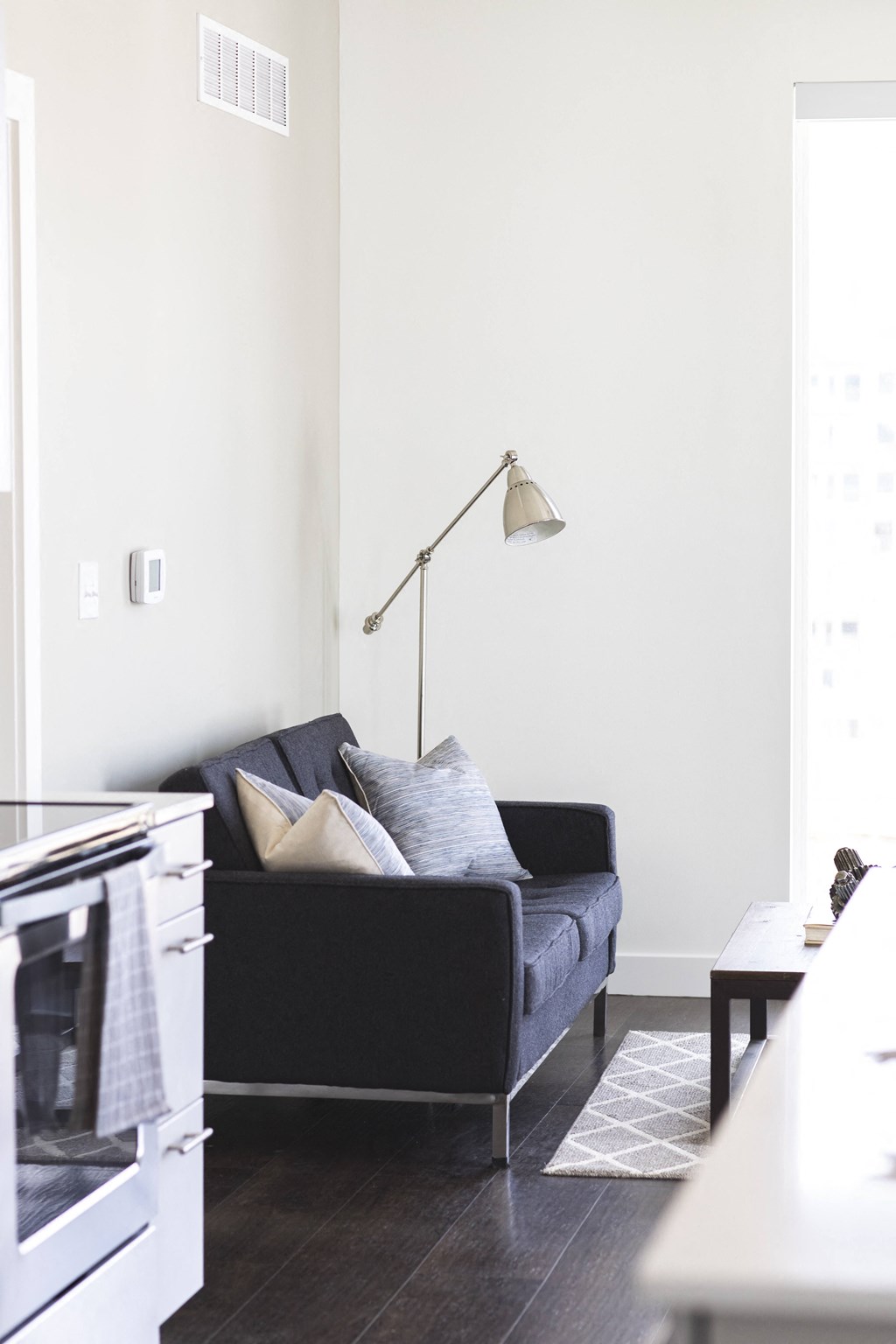 A black couch with pillows sits in a living room.