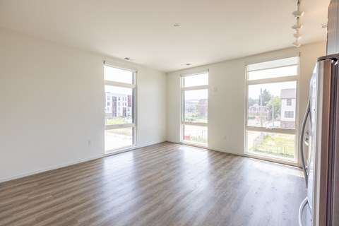 A large empty room with wooden floors and white walls.