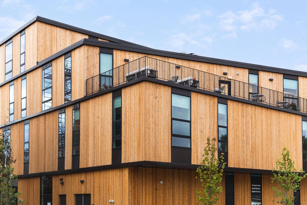 A modern building with a wooden exterior and balconies.