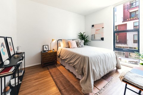 a bedroom with a bed and a large window