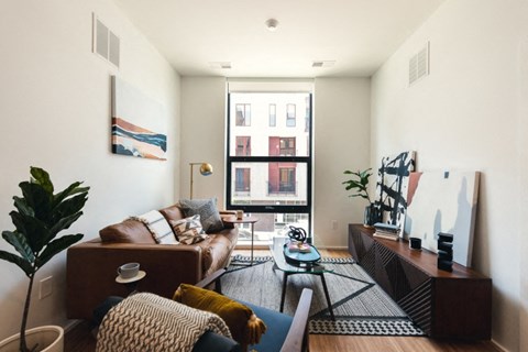 A living room with a brown couch and a coffee table.