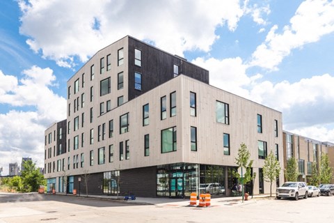 a view of the building from the street with cars parked in front of it