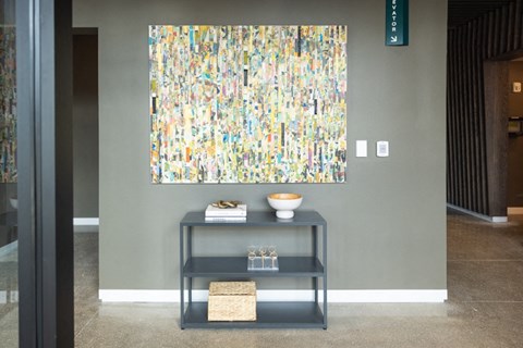 a painting hanging on a wall with a table in front of it