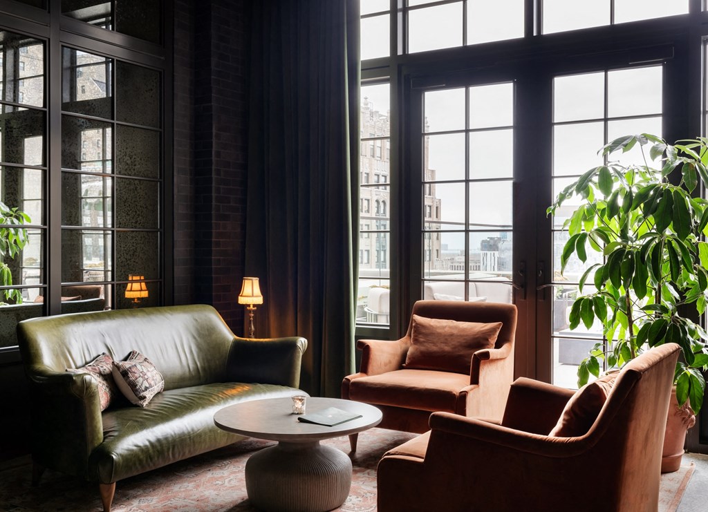 a living room filled with furniture and large windows at Book Tower, Detroit, Michigan