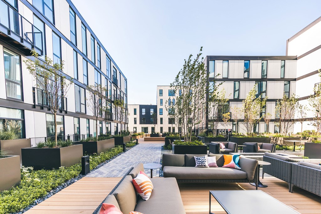 A modern outdoor seating area with couches and tables.