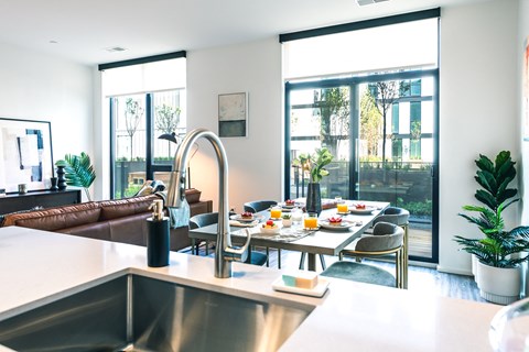 A modern kitchen with a dining table set for a meal.