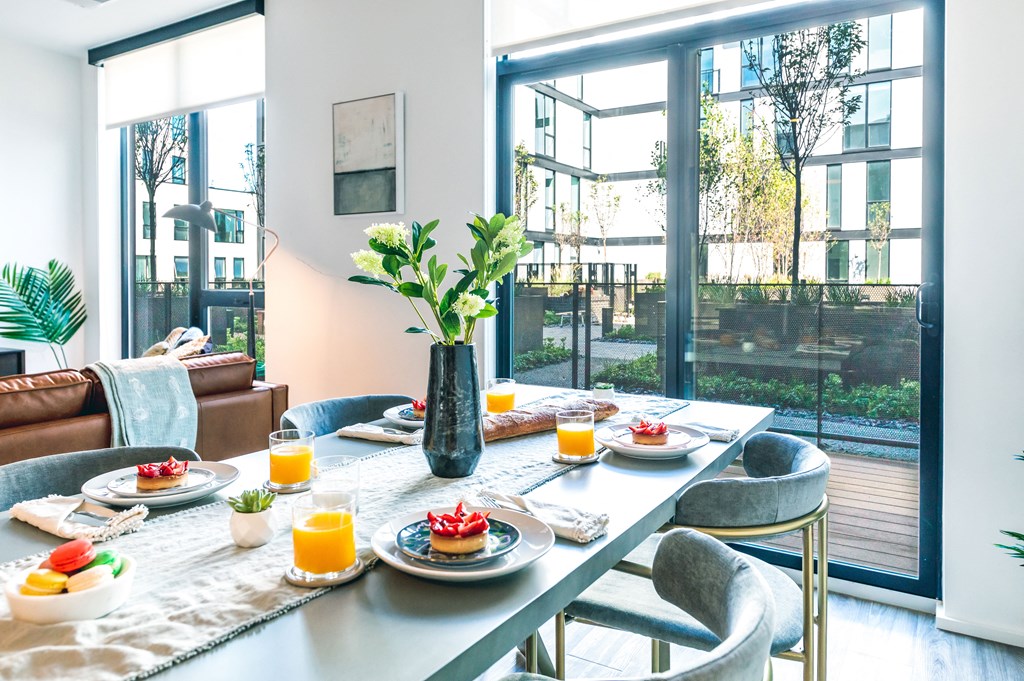 A breakfast table set with plates of food and glasses of orange juice.