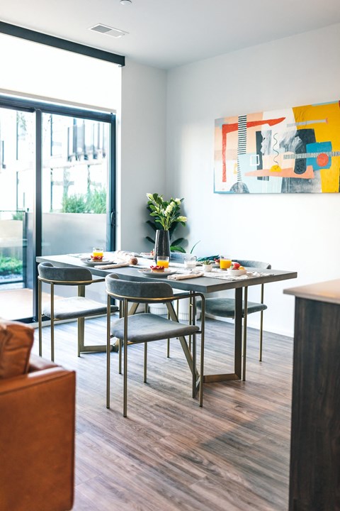 A modern dining room with a table set for four.