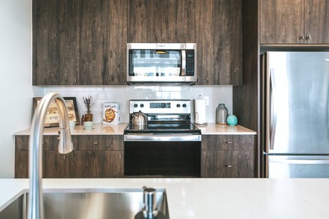 a kitchen with dark wood cabinets and a white counter top