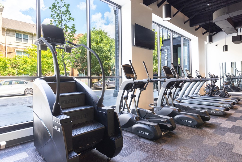 A gym with a variety of cardio equipment including treadmills and elliptical machines.