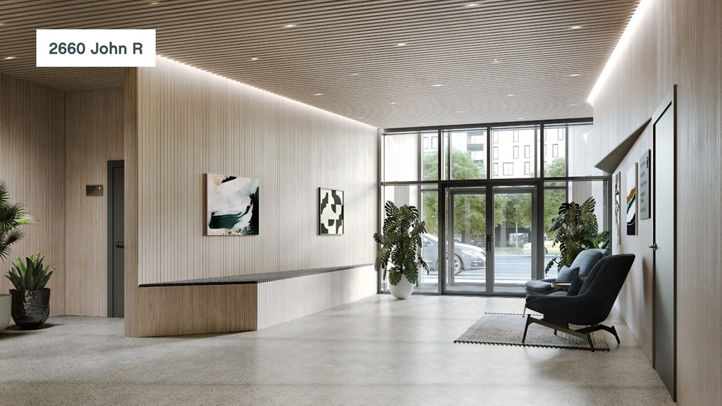 a lobby with a chair and plants and a glass door