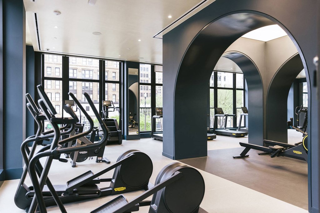 a fitness center with cardio equipment and windows with view of Washington Boulevard at Book Tower, Michigan, 48226