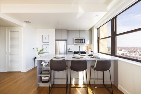 One bedroom unit with open kitchen, a large window and a counter with three chairs at Book Tower, Michigan, 48226
