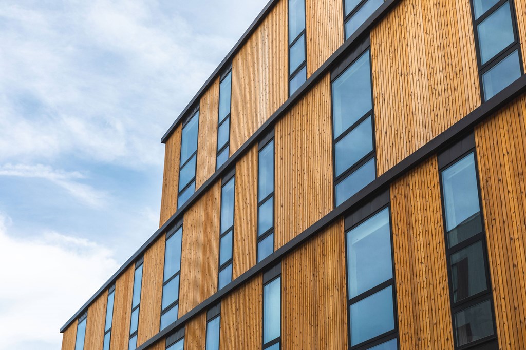A building with wooden panels and black trimmed windows.