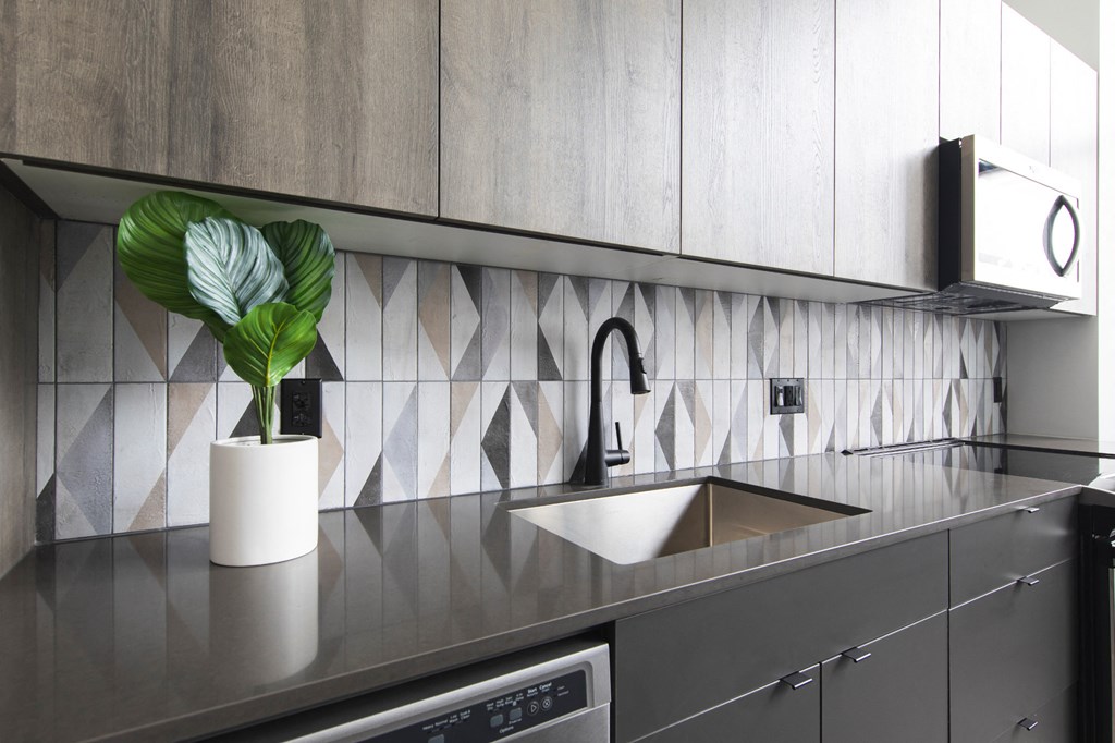 Kitchen faucet in front of elegant backsplash at The May.