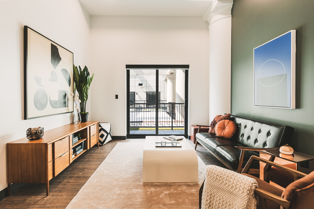 Living room with a green wall and leather sofa at The May, Cleveland, Ohio.