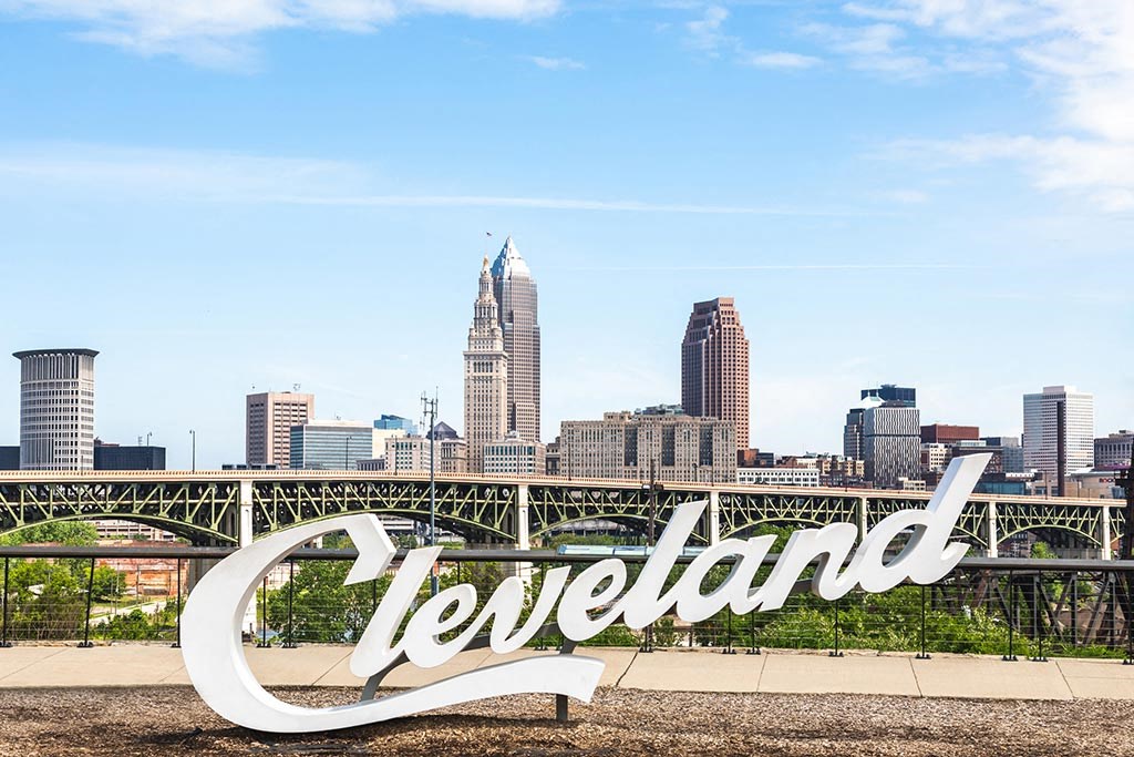 Iconic Cleveland sign with Cleveland skyline in the background.