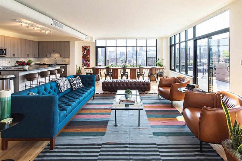 Living Area  with a Blue Couch and Brown Chairs at The Assembly, Detroit, MI
