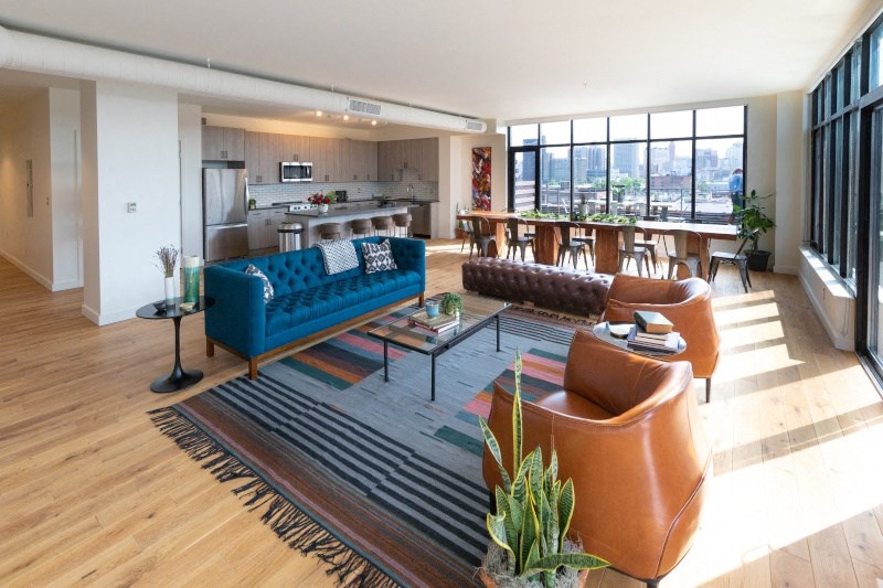 Living Area with a Blue Couch and Carpeting at The Assembly, Detroit, MI