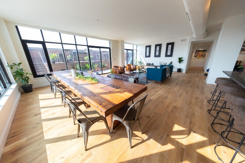 Large Wooden Table with Chairs near a Large Window at The Assembly, Detroit