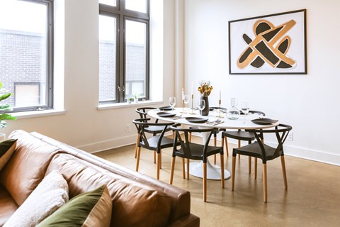 a dining room with a table and chairs and a couch in a 555 waverly unit at The Ferguson Apartments, Detroit, Michigan