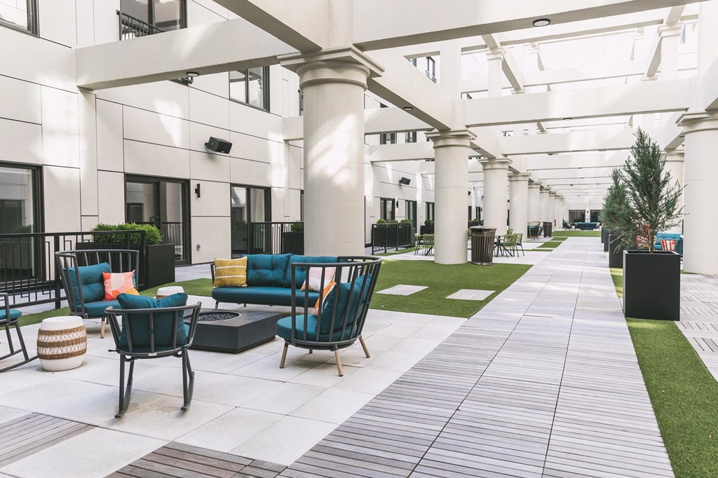 Outdoor community atrium with seating and built-in fire pits at The May.