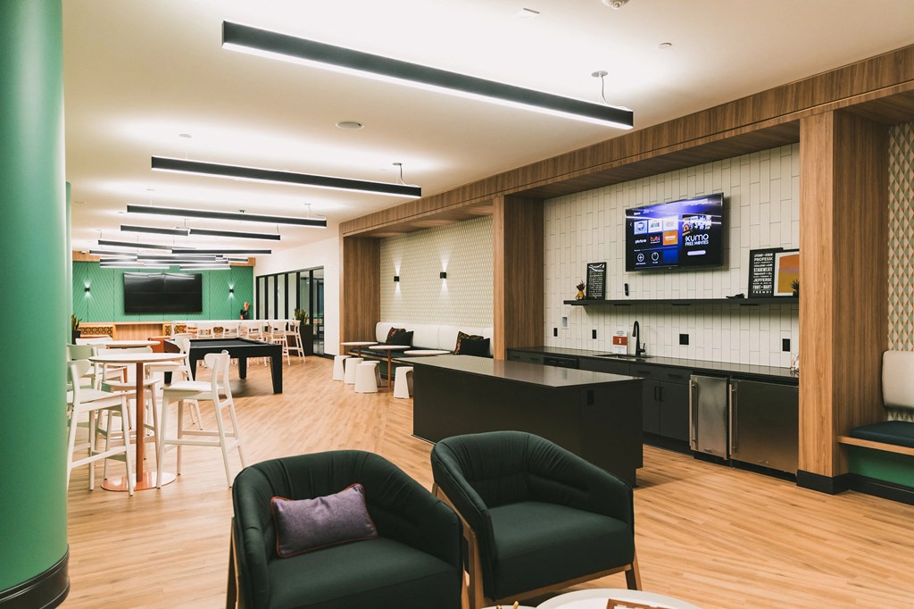 Community room with TVs, lounge area, and billiard table at The May.