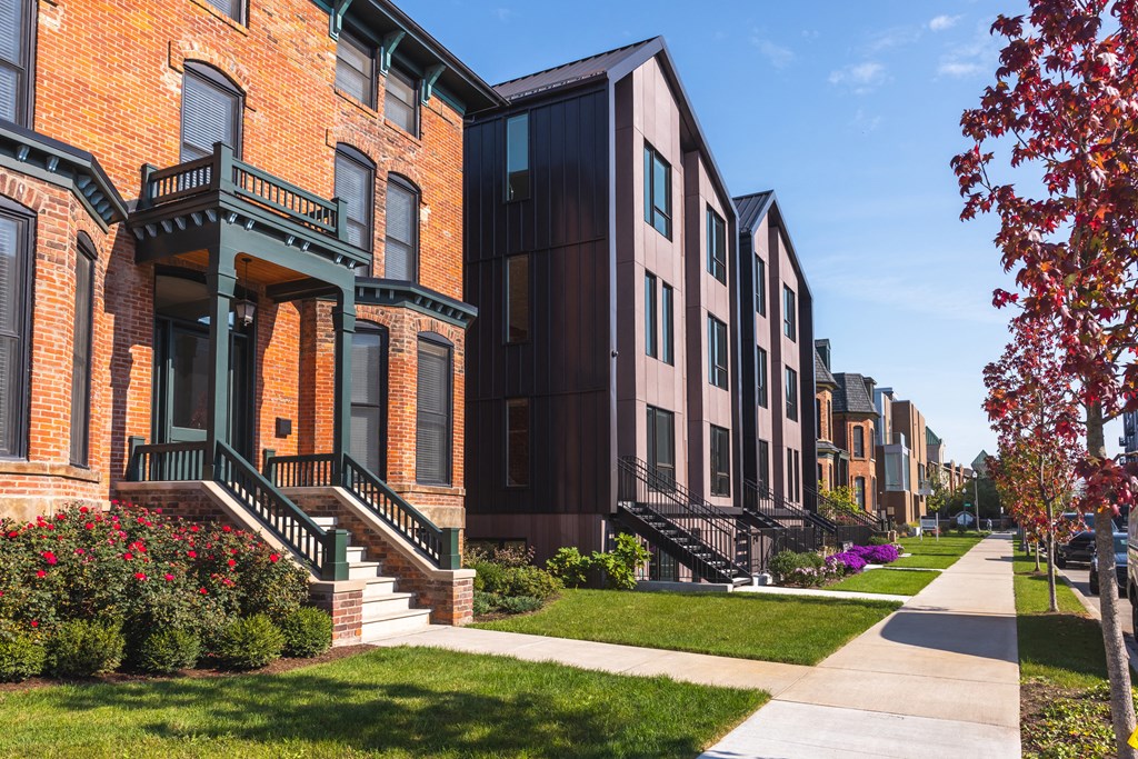 A row of houses with green steps leading to the front door.