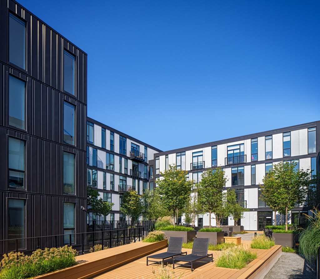 a rendering of a courtyard with tables and chairs in front of buildings