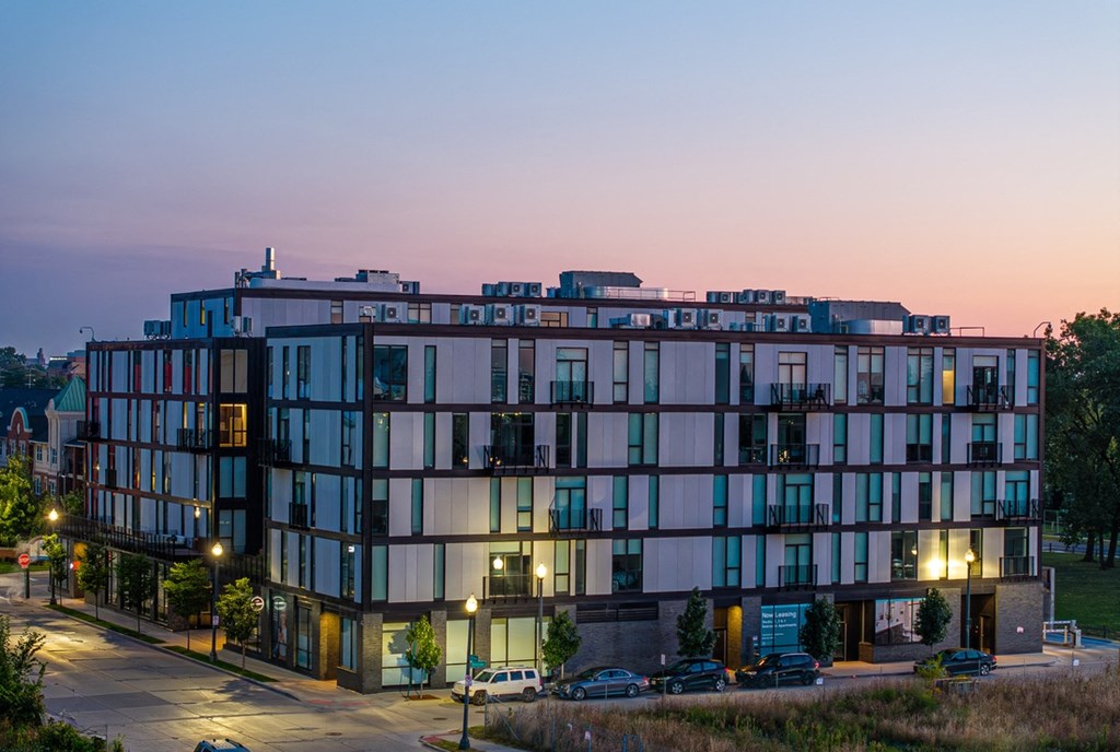 a view of a building at dusk with street lights