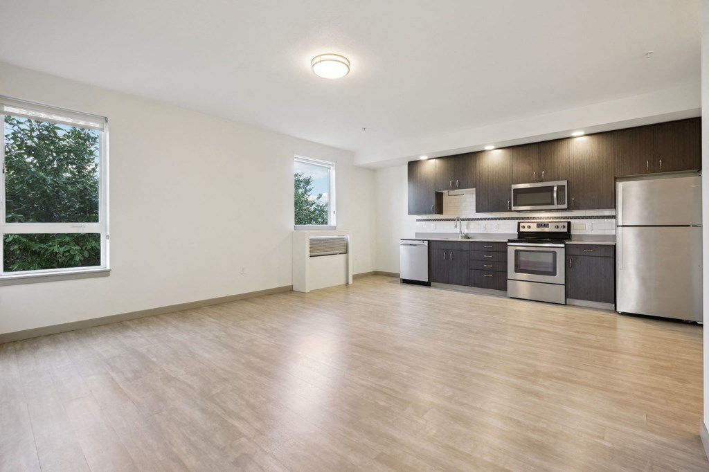 A kitchen with a refrigerator, microwave, oven, and dishwasher.